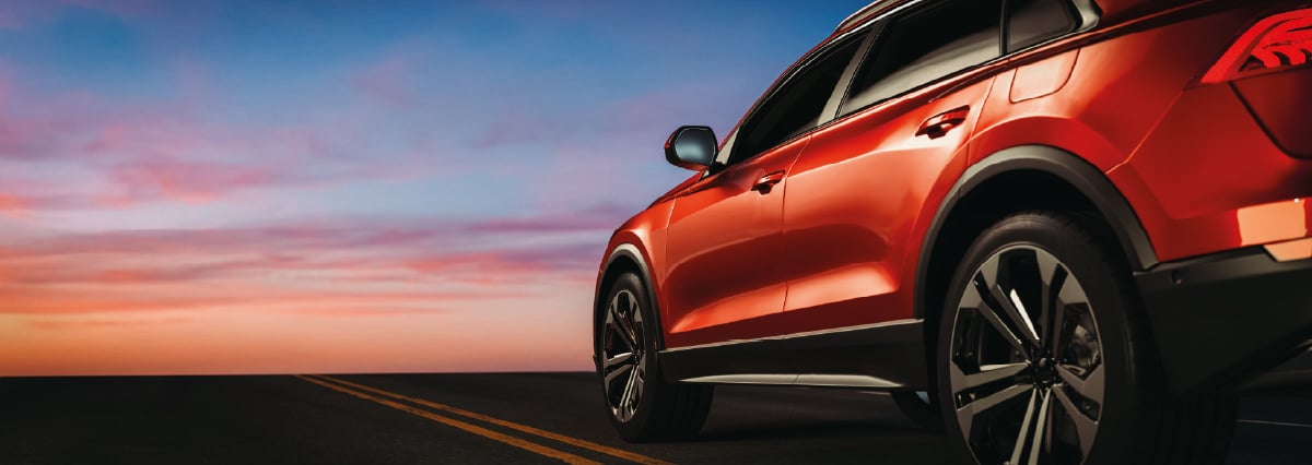 SUV rouge au coucher du soleil.