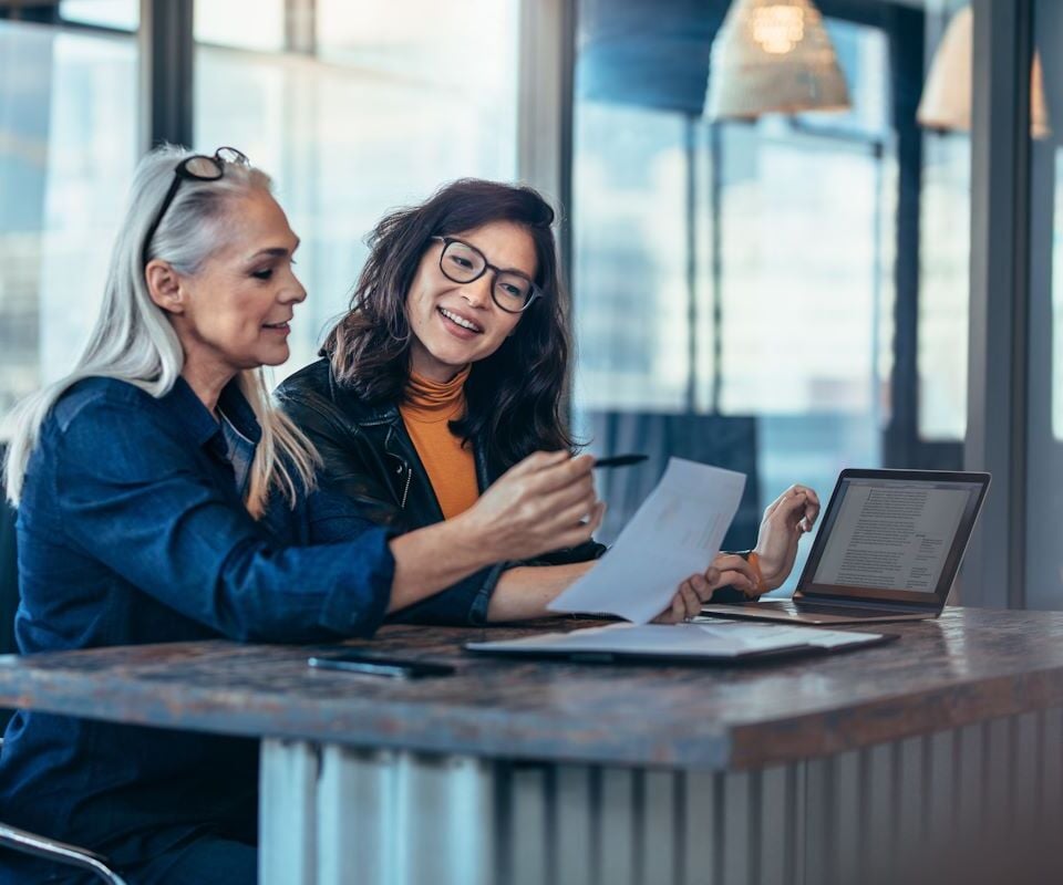 Deux femmes discutent devant un ordinateur